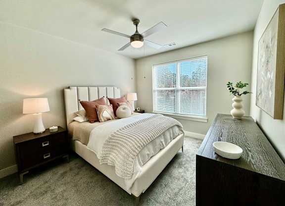 A bedroom with a large bed, a ceiling fan, and a nightstand with a lamp at The Collective Upper Westside Apartments, Atlanta, 30318