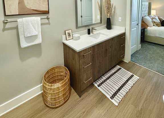 A bathroom with a wooden vanity and a mirror above it at The Collective Upper Westside Apartments, Atlanta, GA