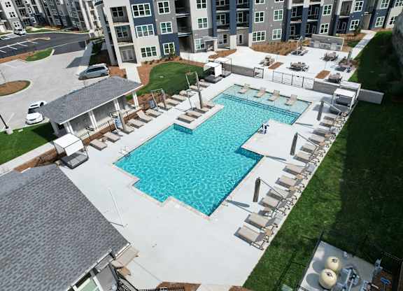 An aerial view of a swimming pool surrounded by lounge chairs and buildings in the background. at The Percy Apartments, Nashville, TN