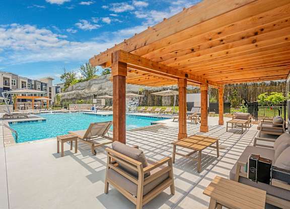 A wooden pergola over a pool with sun loungers at The Percy Apartments, Nashville, TN