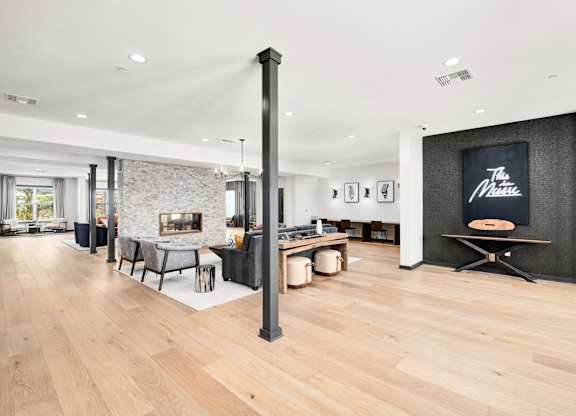 A modern living room with a fireplace and a dining table at The Percy Apartments, Nashville