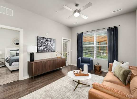 A modern living room with a brown sofa and a wooden coffee table at The Percy Apartments, Tennessee, 37214