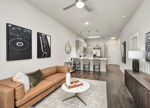 A living room with a tan couch and a coffee table in the middle at The Percy Apartments, Nashville