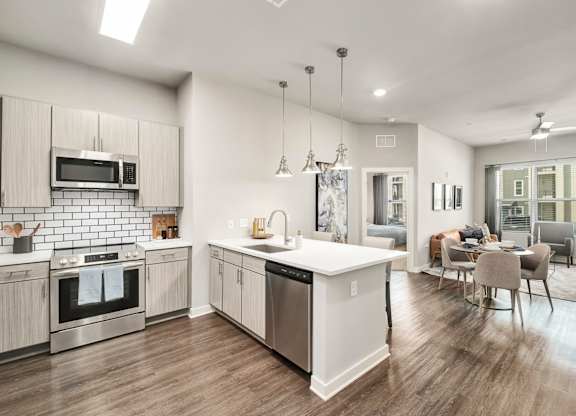 A modern kitchen with wooden floors and stainless steel appliances at The Percy Apartments, Nashville, TN
