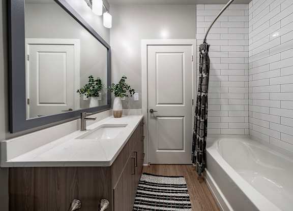 A white sink with a mirror above it at The Waverly at Winter Haven Apartments, Florida