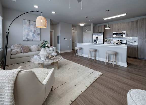 A modern living room with a white sofa and a grey armchair at The Waverly at Winter Haven Apartments, Winter Haven, 33884