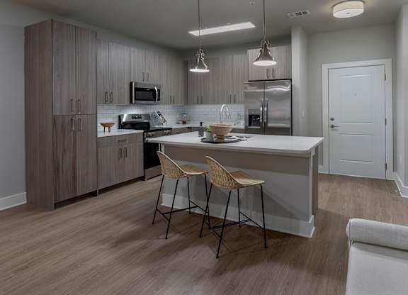 A modern kitchen with a dining table and chairs at The Waverly at Winter Haven Apartments, Winter Haven