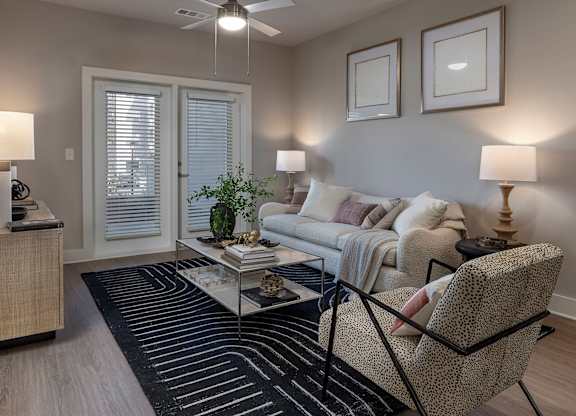 A living room with a couch, chair, and two lamps at The Waverly at Winter Haven Apartments, Winter Haven, FL