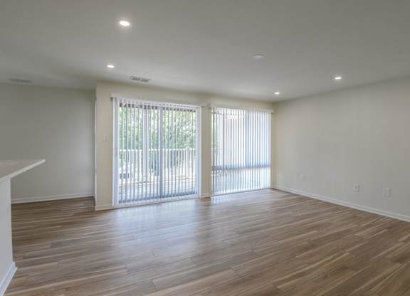 A room with wooden floors and sliding glass doors.