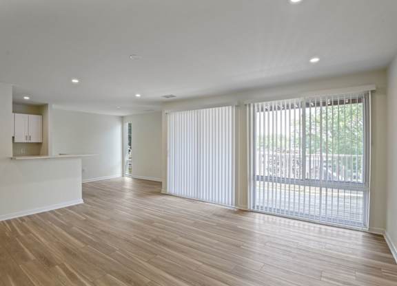 A large empty room with wooden floors and white walls.