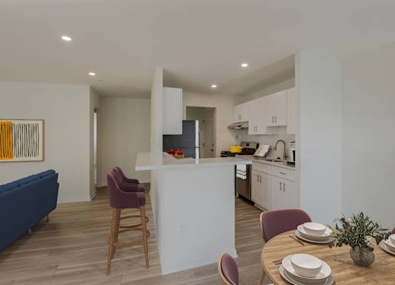 A modern kitchen with a dining table set for two.