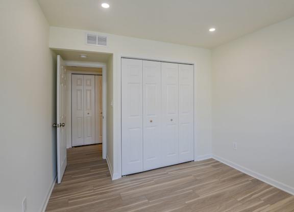 A room with a white door and a white closet.