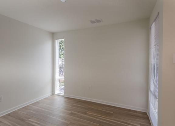 A room with wooden flooring and a window.