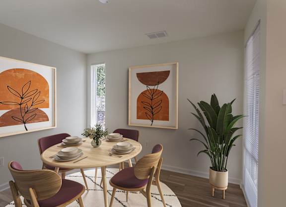 A dining room with a round table and chairs.