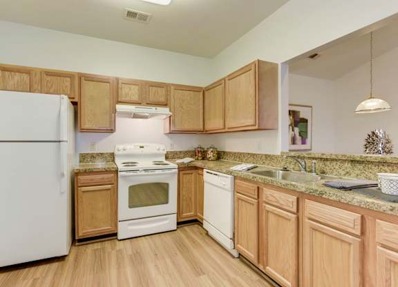 a kitchen with white appliances and wooden cabinets