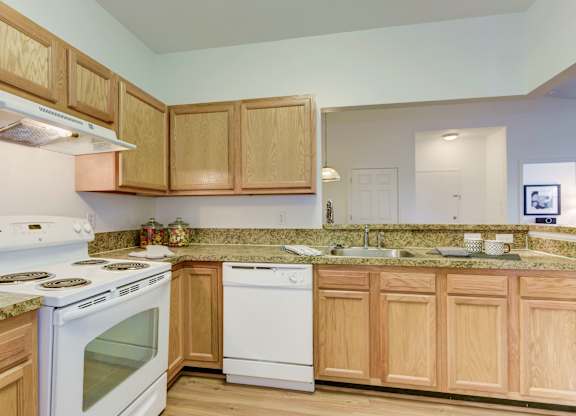 a kitchen with white appliances and wooden cabinets