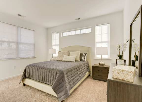 a bedroom with a bed and two windows