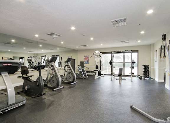 A gym with treadmills, elliptical machines, and other exercise equipment.