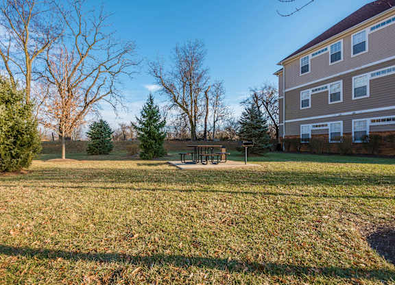 a yard with a picnic table in front of a house