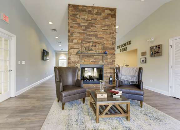 a living room with a fireplace and two chairs