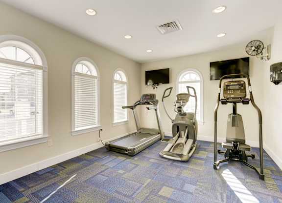a home gym with exercise equipment and windows