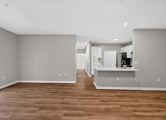 A kitchen with a refrigerator, sink, and cabinets.