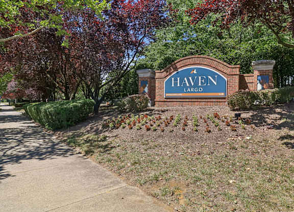 A sign that says Haven Largo is in front of a tree.