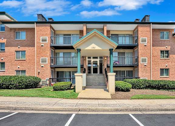 A large brick building with a balcony and a small entrance.