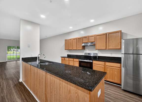 A kitchen with wooden cabinets and a black countertop.