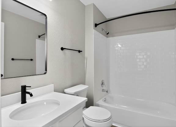 A white bathroom with a sink, toilet, and bathtub.