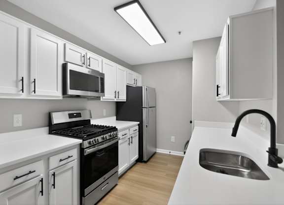 A kitchen with white cabinets and appliances.