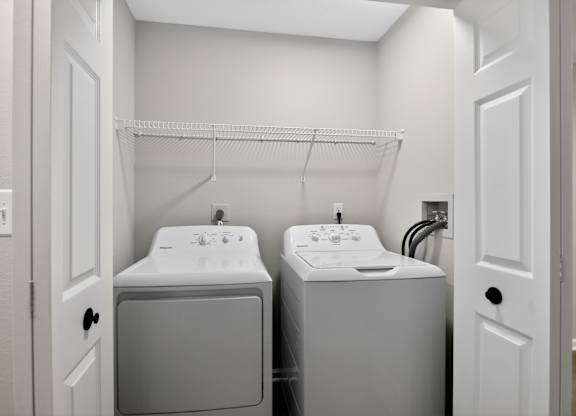 A small bathroom with a sink and a washer and dryer.