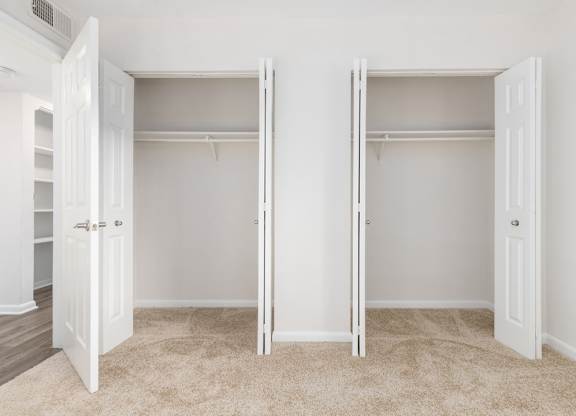 Two white closet doors with shelves inside.