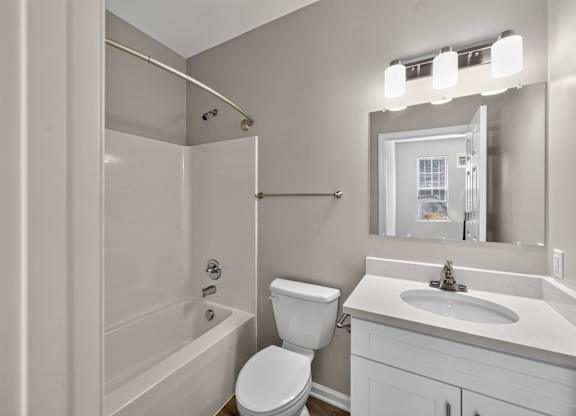 A white bathroom with a toilet, sink, and bathtub.