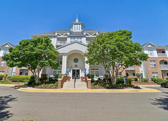A large building with a tower and a gate in front.