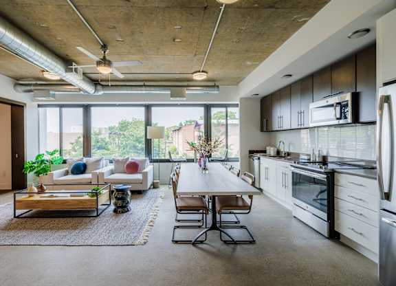A modern kitchen with a dining table and chairs in the middle of the room.