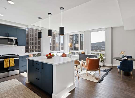 A modern kitchen with a large island and a dining area.