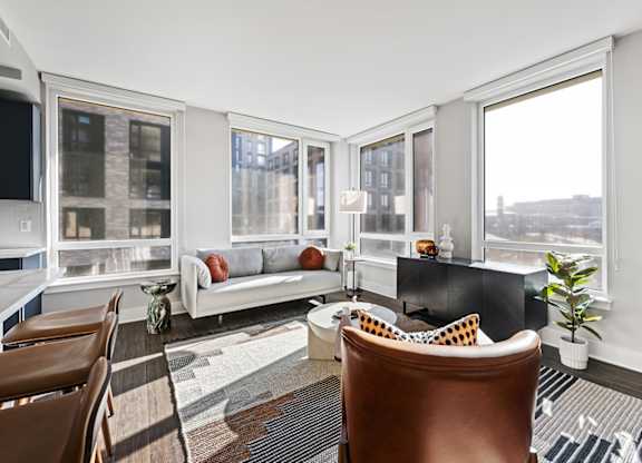 A living room with a brown leather chair and a white couch.