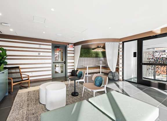 A modern living room with a striped wallpaper and a glass door leading to a balcony.