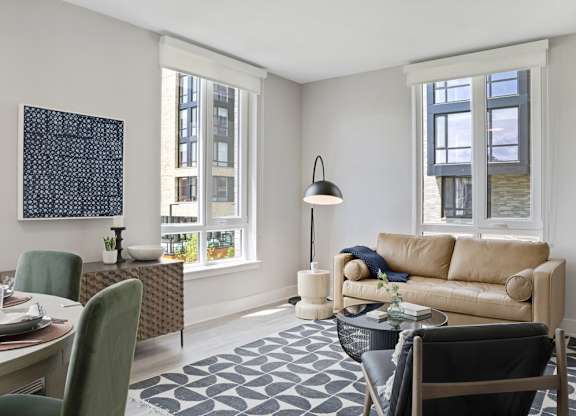 A living room with a couch, chairs, and a table.