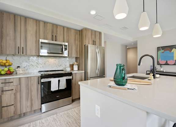 A modern kitchen with wooden cabinets and stainless steel appliances.