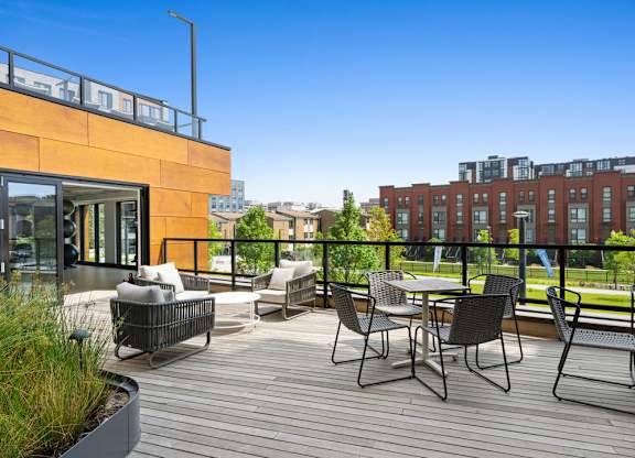 A patio with a table and chairs overlooking a cityscape.