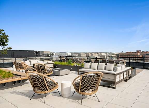 A patio with chairs and a table overlooking a cityscape.
