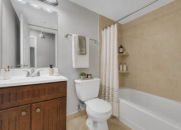 A white toilet sits in a bathroom next to a white sink.