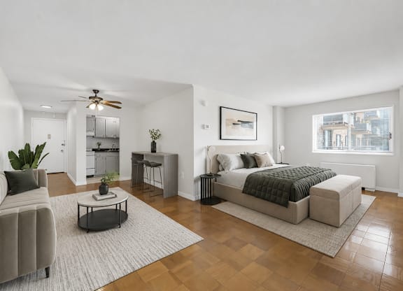 A modern bedroom with a large bed and a living area with a couch.