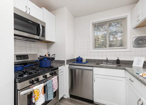 A kitchen with a stove, microwave, and dishwasher.
