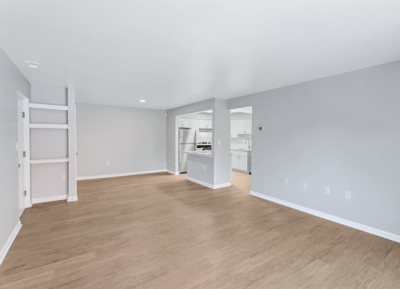 a living room with a hard wood floor and a kitchen
