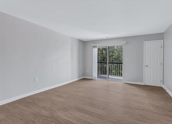 an empty living room with a door to a balcony