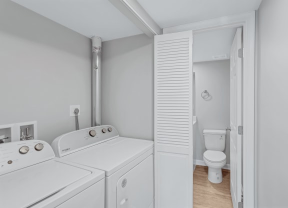 a washer and dryer in a laundry room next to a toilet