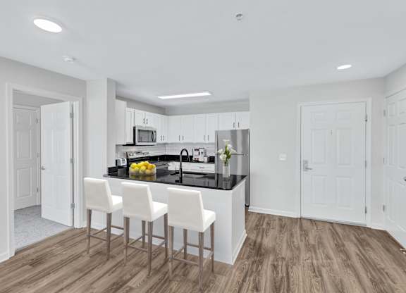 a kitchen with white cabinets and a black counter top